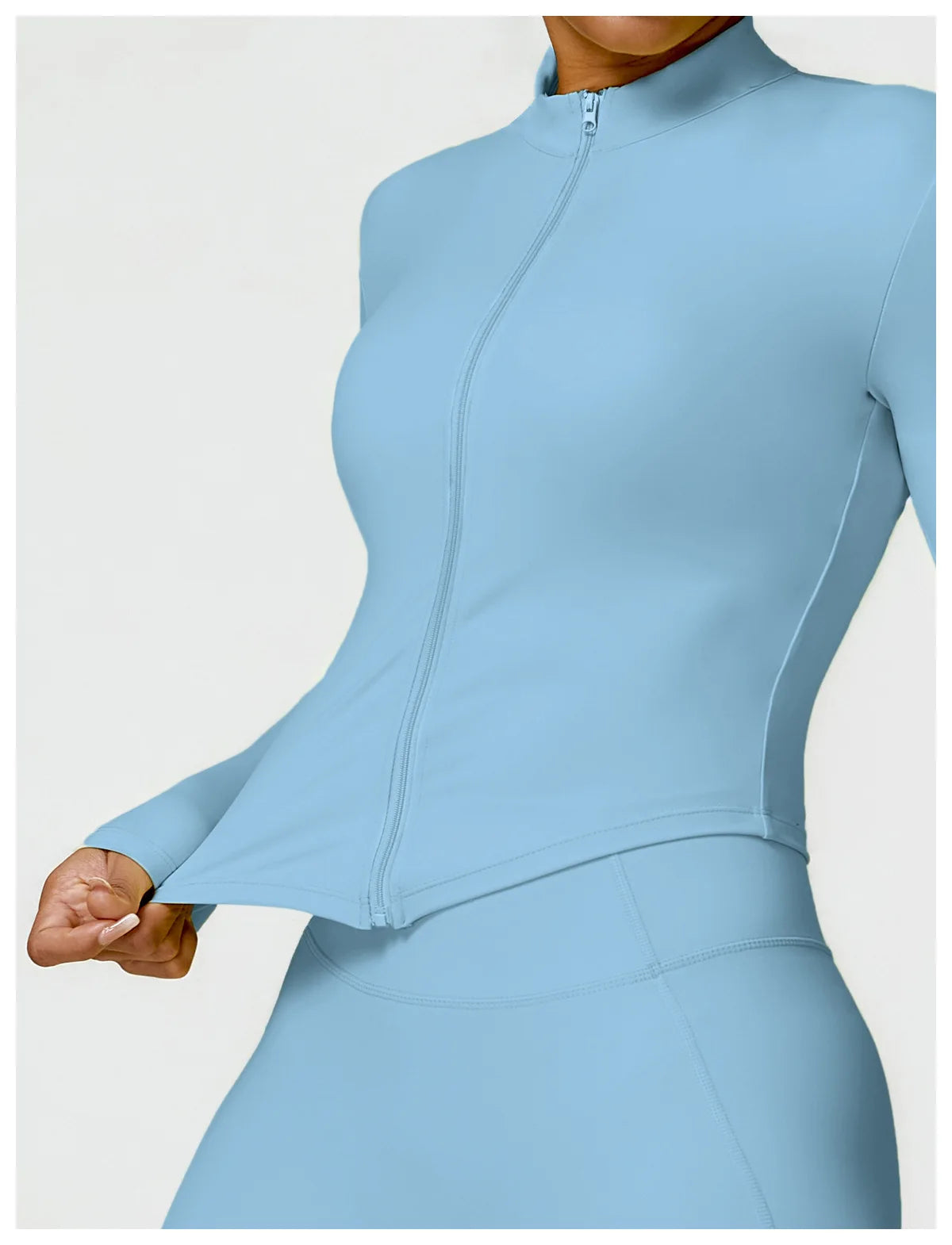 KiKis women's gym workout zip up top in light blue stretch fabric shown from front