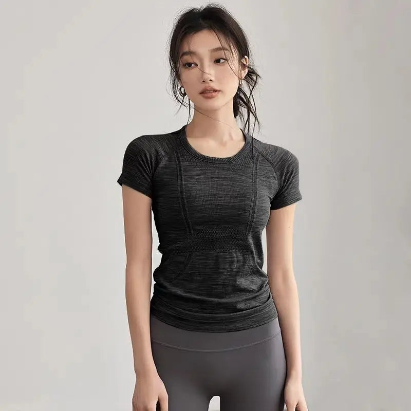 Woman wearing KiKis women's long sleeve yoga top in black posing against a plain background