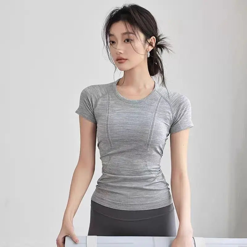 KiKis women's long sleeve yoga top in gray fitted design on model with black leggings