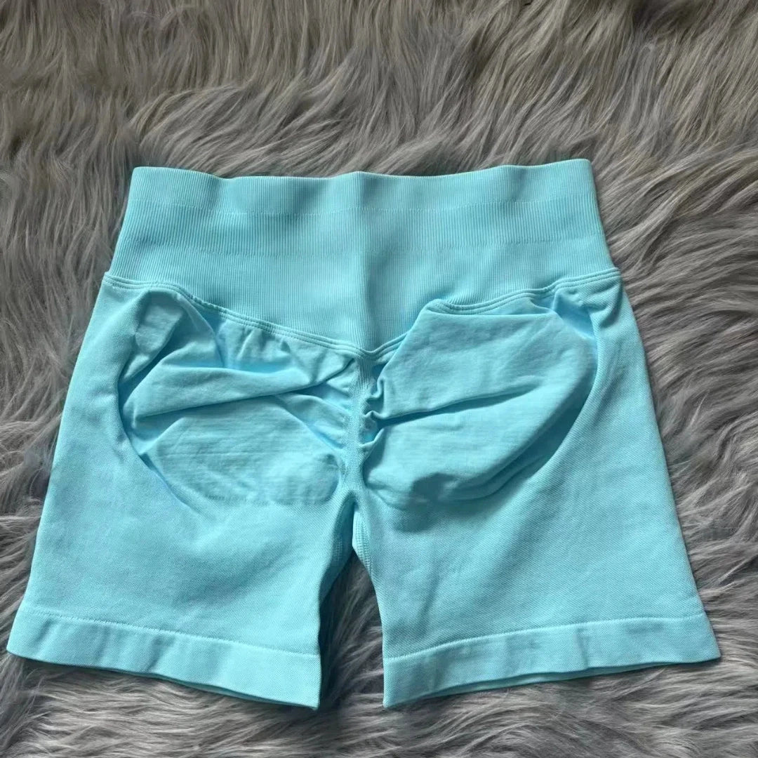 KiKis women's peach hip yoga shorts in light blue with ruched back detail on gray background