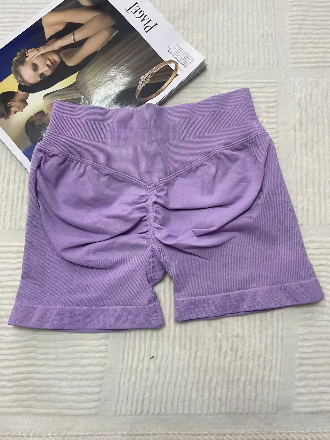 KiKis women's peach hip yoga shorts in light purple with ruched back detail for a flattering fit