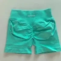 KiKis women's peach hip yoga shorts in teal color with ruched detailing on the back