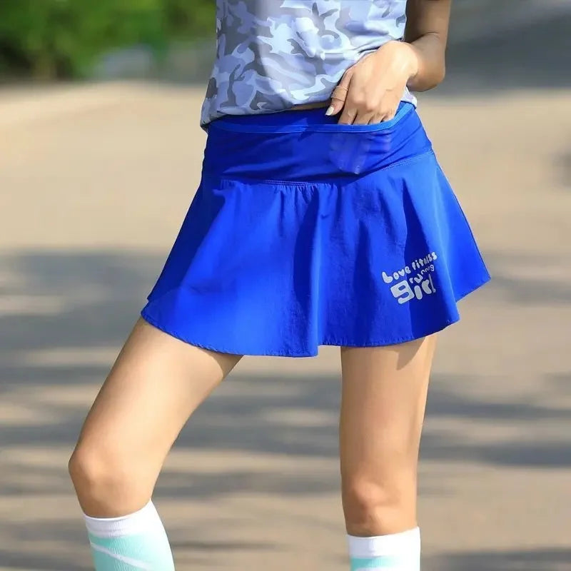 KiKis women's quick dry tennis skirt in blue worn outdoors with camouflage top and knee-high socks