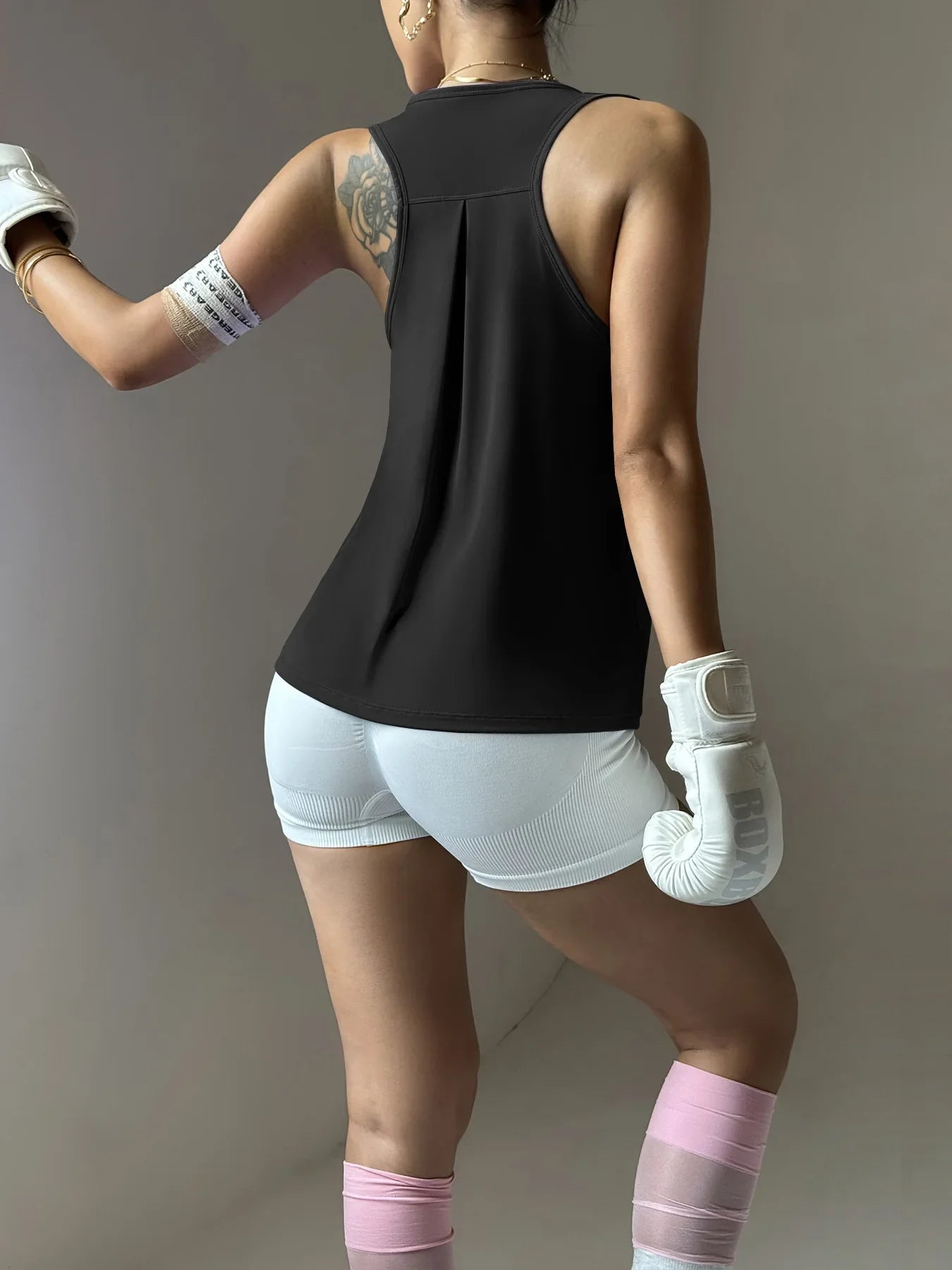 KiKis women's quick dry yoga top in black shown from back with sleeveless design and racerback style