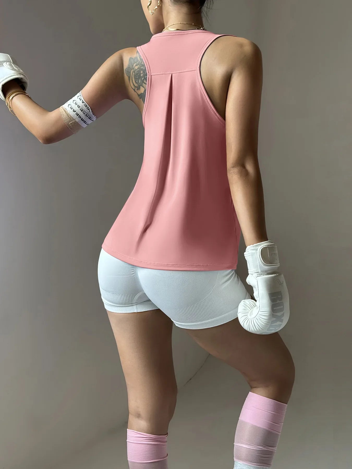 KiKis women's quick dry yoga top in pink racerback design worn with white shorts and boxing gloves