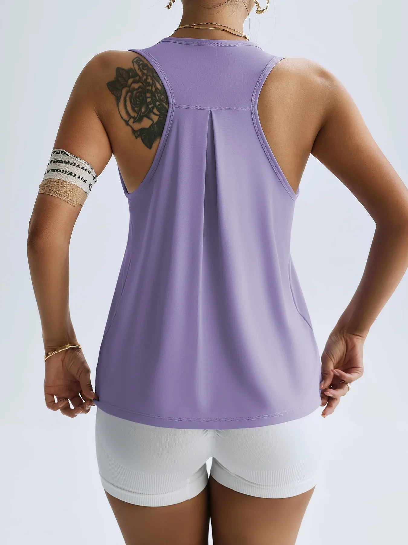 Back view of women's quick dry yoga top in lavender by KiKis paired with white shorts