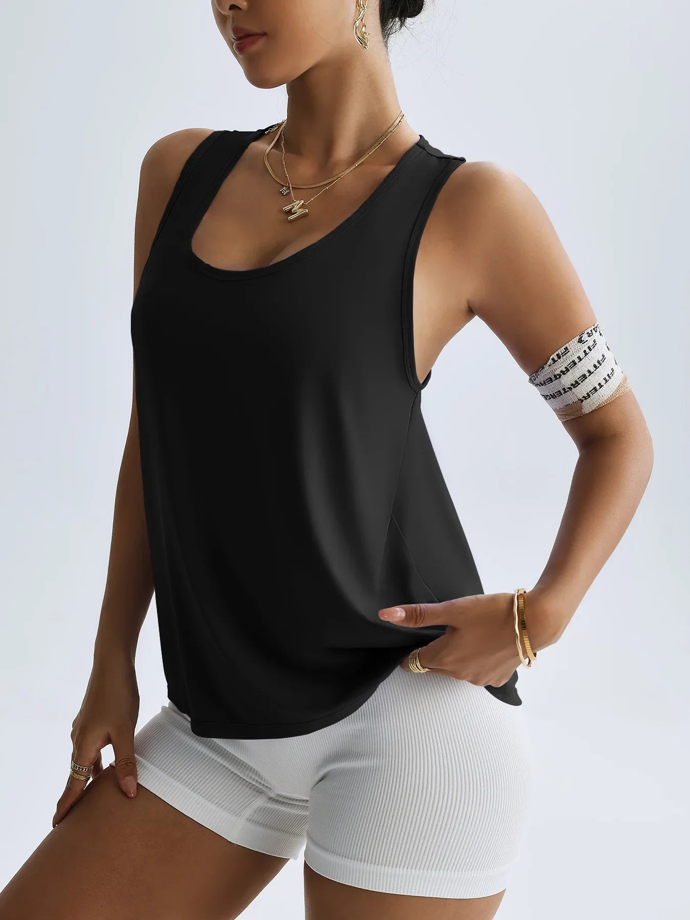 KiKis women's quick dry yoga top in black sleeveless design worn with white shorts