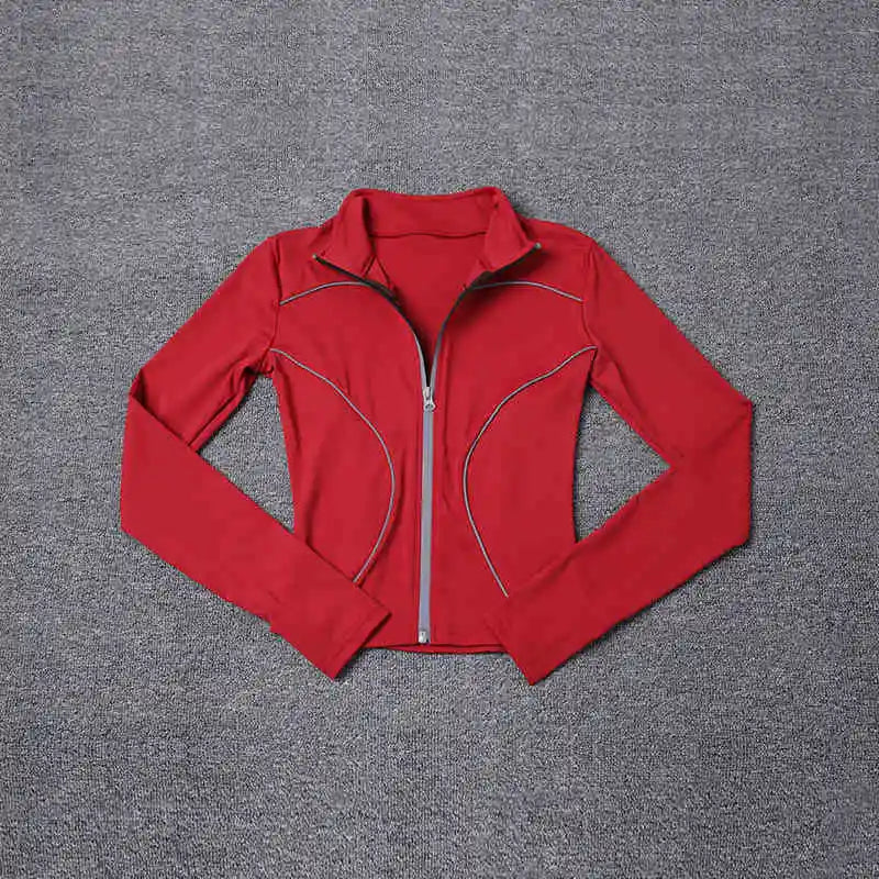 Red women's reflective yoga jacket with full zipper and long sleeves laid flat on gray surface