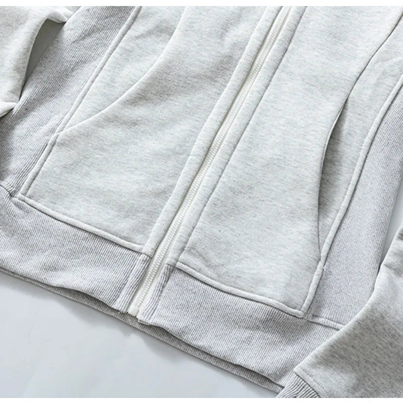 Close-up of light gray women's running zip up hoodie with front pockets and ribbed hem by KiKis