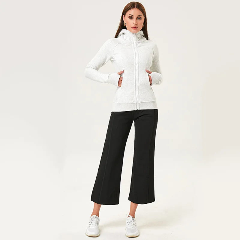 KiKis women's running zip up hoodie in white worn with black pants and white sneakers