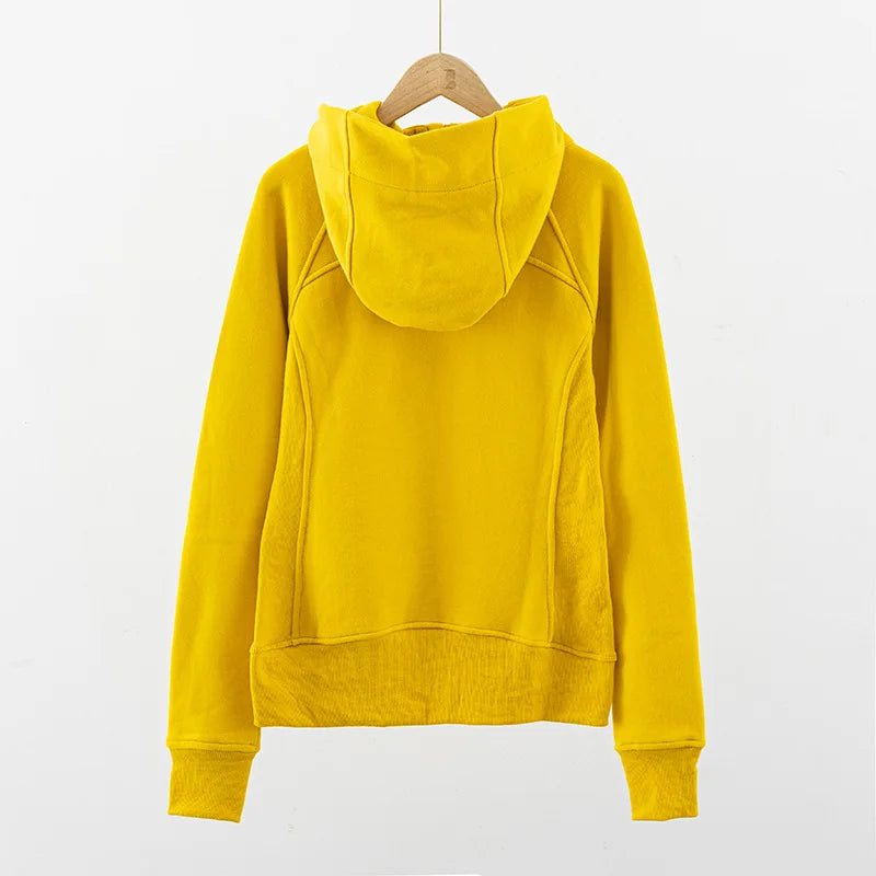 Back view of yellow women's running zip up hoodie by KiKis hanging on wooden hanger
