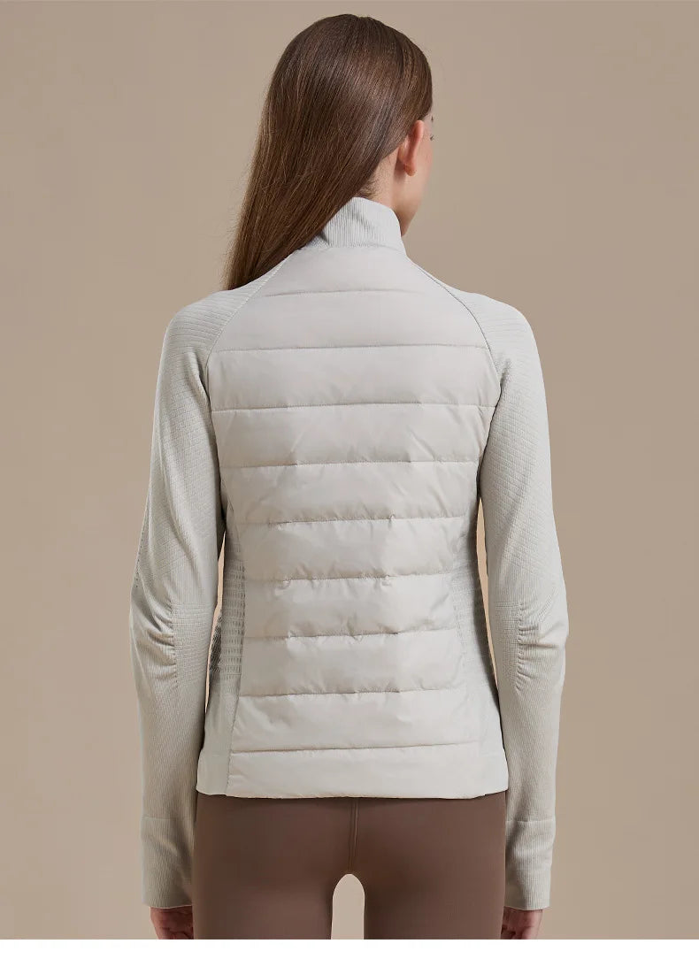 Back view of women's short down jacket in light gray with quilted back and knit sleeves