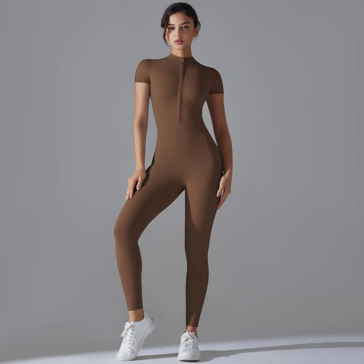 KiKis women's zipper yoga jumpsuit in brown with short sleeves and front zipper, worn with white sneakers