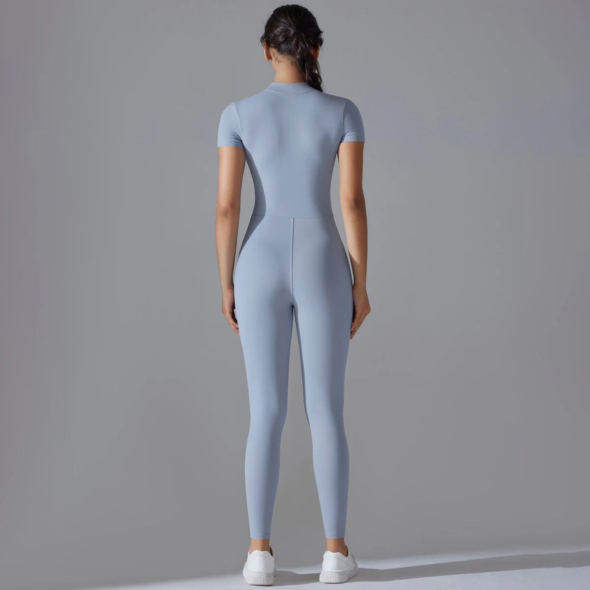 Back view of women's zipper yoga jumpsuit in light blue fitted design for activewear