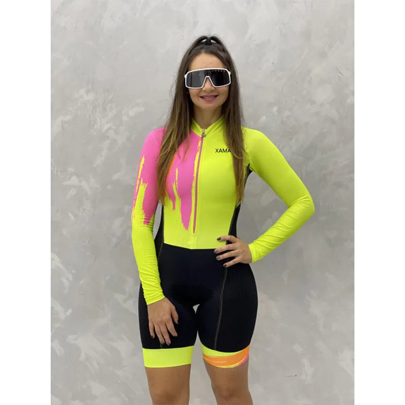 Woman wearing KiKis XAMA women's cycling jumpsuit in neon yellow pink and black with long sleeves and front zipper