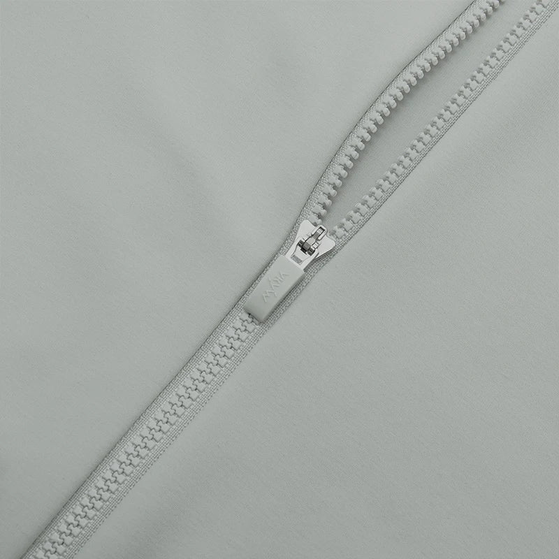 Close-up of zipper on KiKis women's thermal cycling jacket in light gray fabric