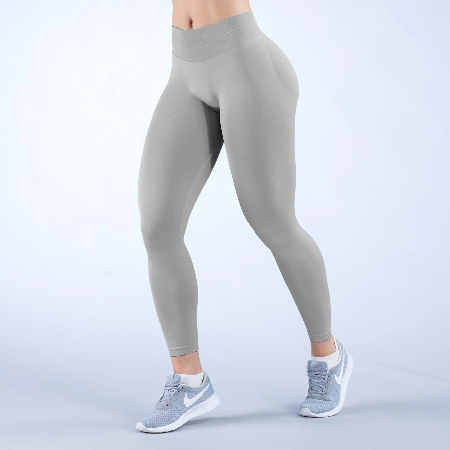 KiKis high-waisted seamless sports leggings in light gray worn with gray Nike running shoes
