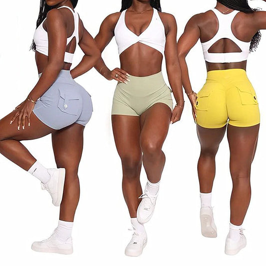 Three women wearing women's scrunch booty shorts in blue, beige, and yellow with white athletic tops and sneakers