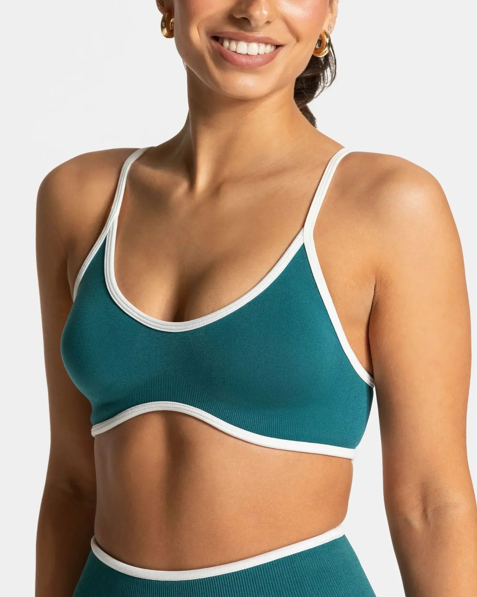 KiKis shockproof yoga bra outdoor fitness in teal with white trim on smiling woman
