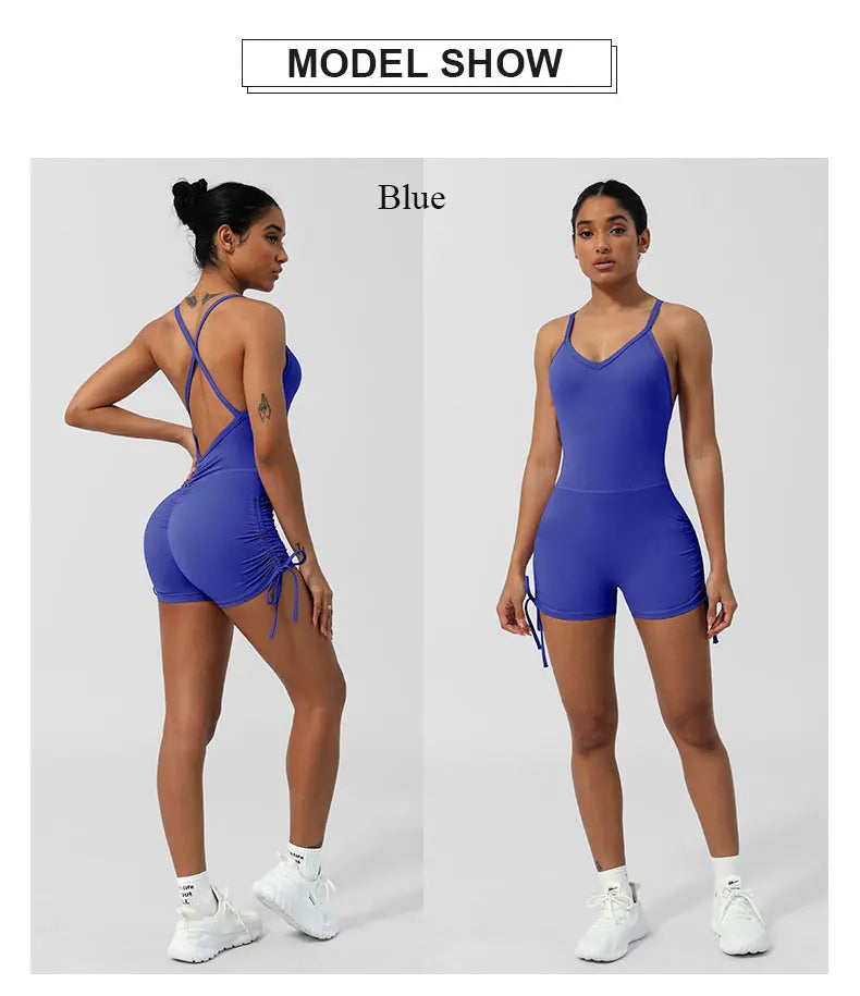 Blue women's cross back yoga jumpsuit by KiKis shown from front and back on model with sporty white sneakers
