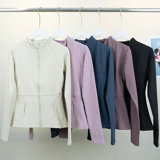 KiKis women's fleece yoga jacket in cream, pink, blue, mauve, and black hanging on white hangers