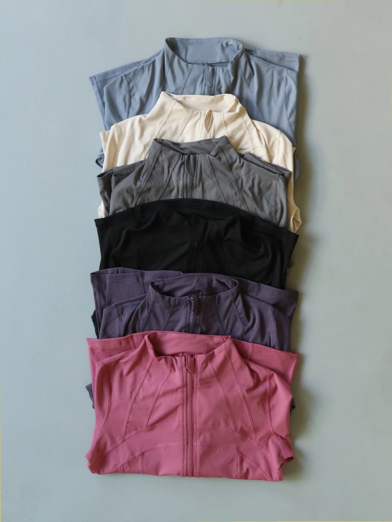 KiKis women's lightweight zipup activewear jackets in various colors neatly folded