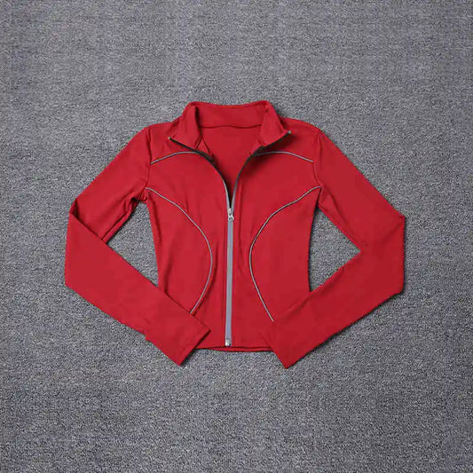 Red women's reflective yoga jacket with full zipper and long sleeves laid flat on gray surface